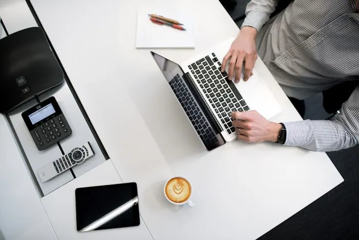 Tidy desk with a laptop and an office phone, a bookkeeper at work