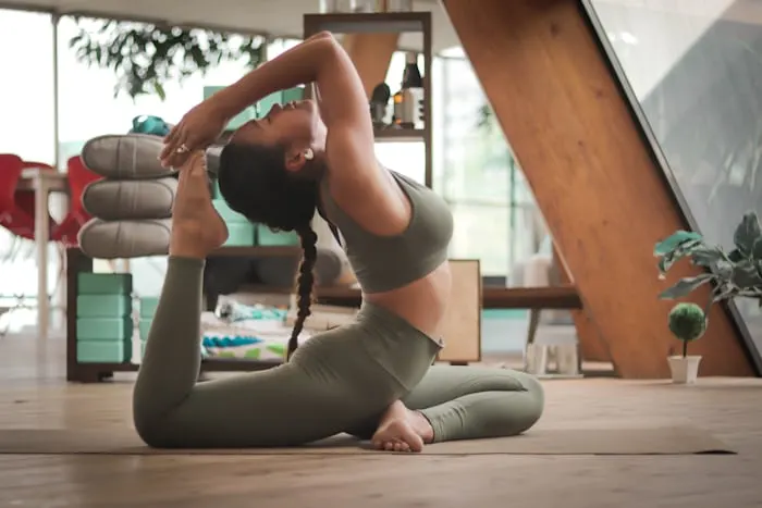 A woman in a yoga pose in a bright studio