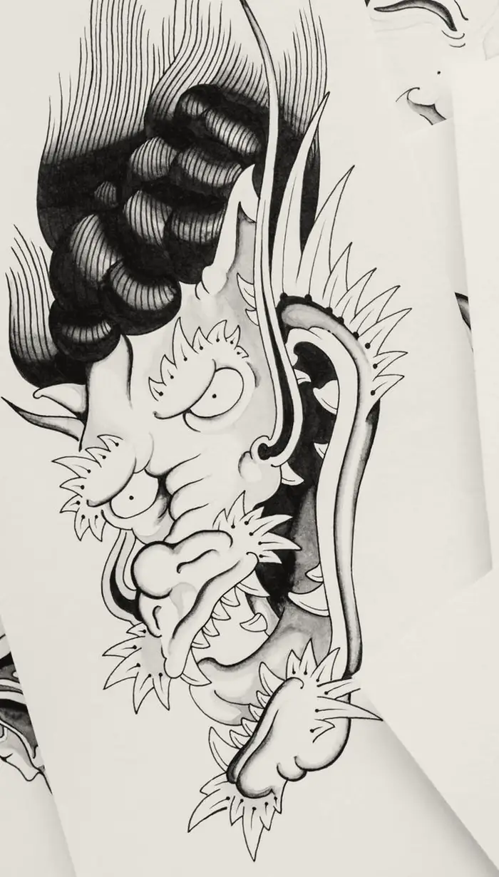 Japanese-style dragon head with bold black linework, drawn on paper