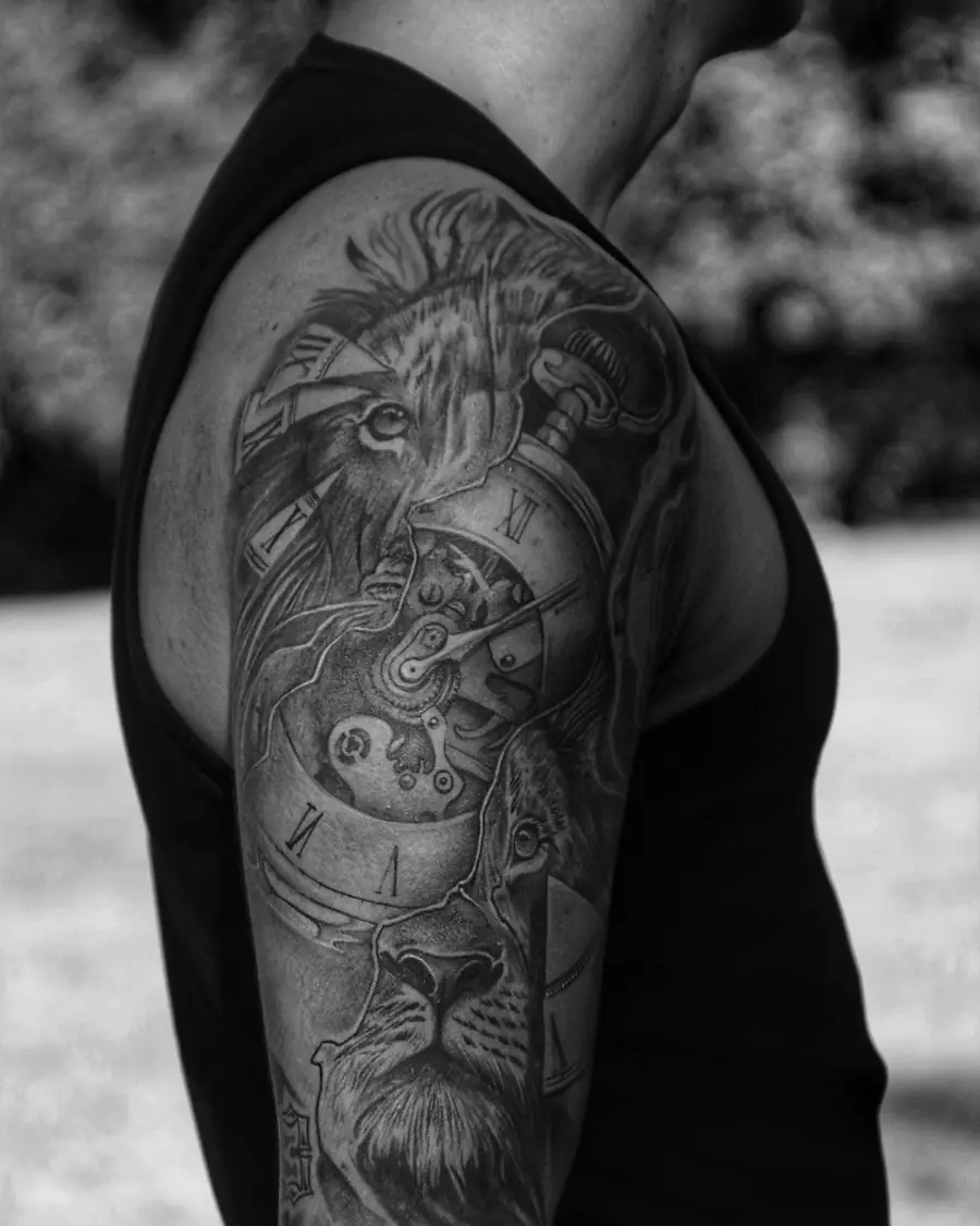 Lion and clock in black and grey realism across the shoulder and upper arm